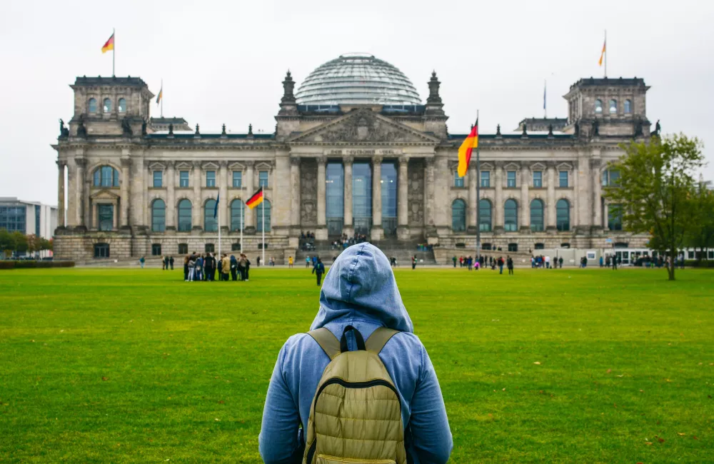 A young woman with backpack looking at Bundestag building in Berlin.