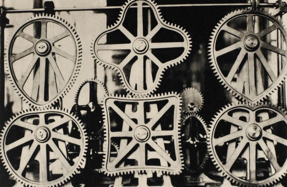 A black and white image by Germaine Krull from 1928 depicting metal cogs and gears.