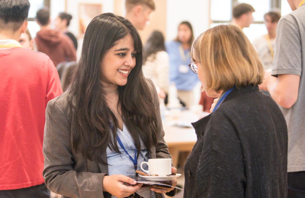 A Trinity College postgraduate student chats to the college president at an event in the college cafe.