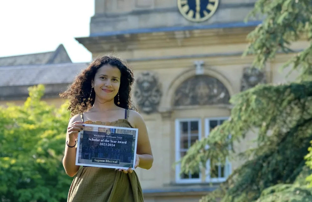 Sagoon Bhetwal stands with her Scholar of the Year award certificate outside Trinity's chapel.