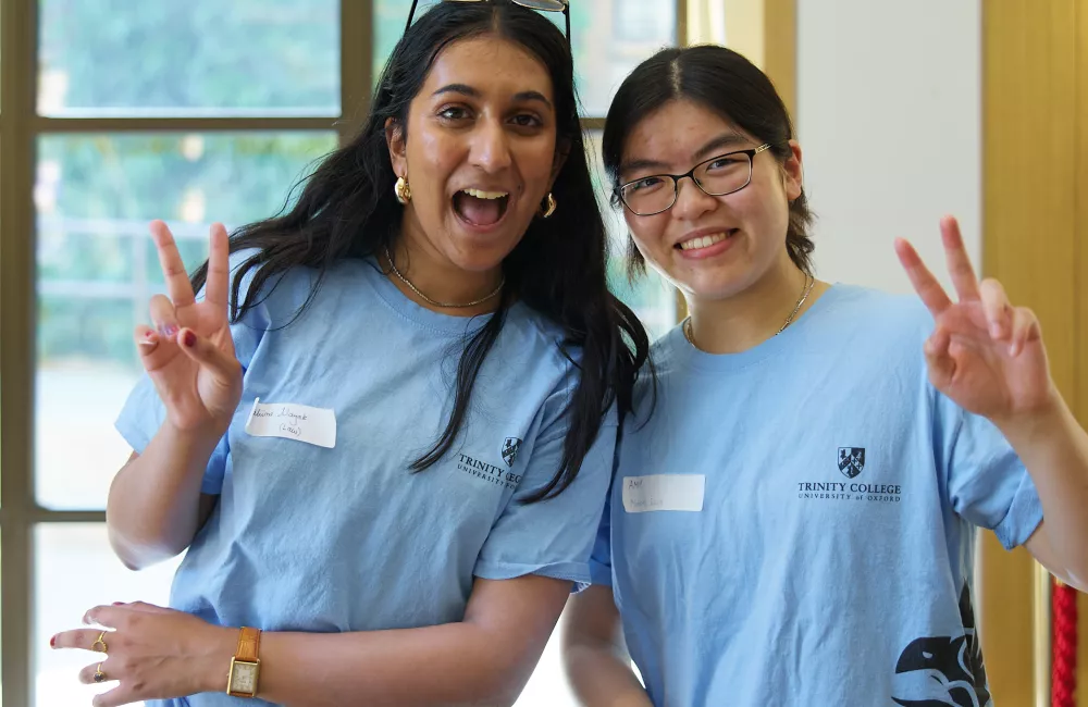 Two Trinity College student ambassadors flash peace signs.