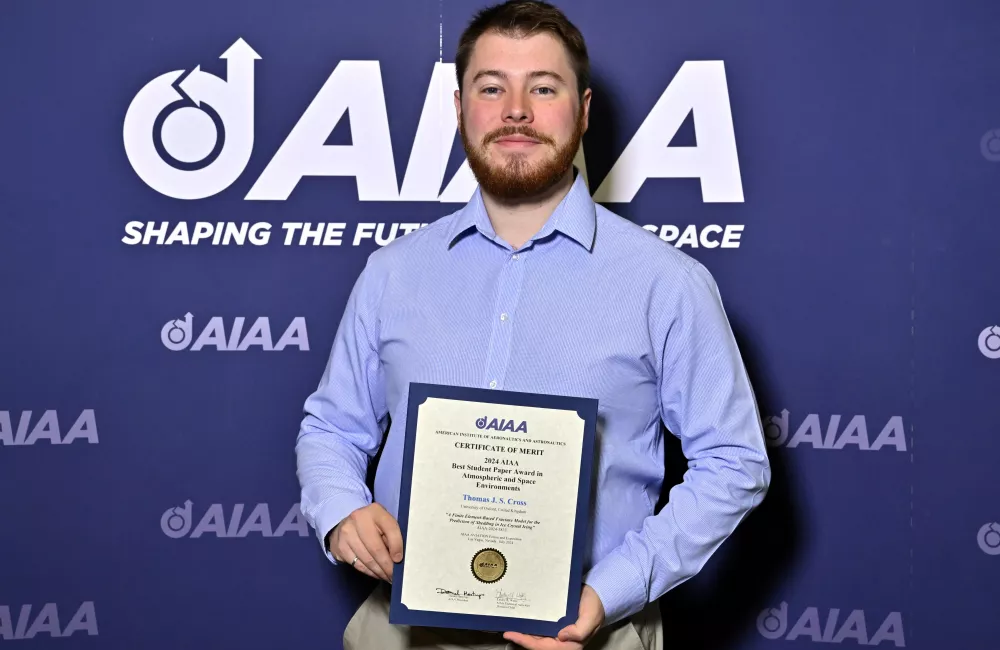 Thomas Cross holds his award