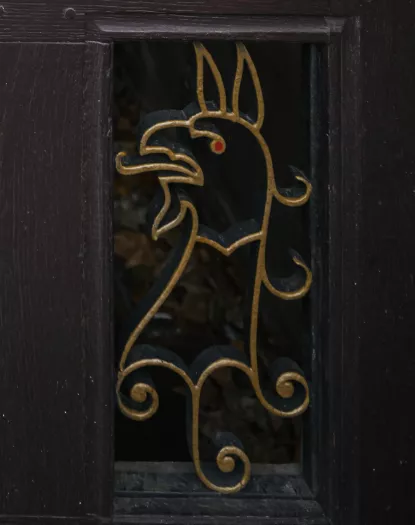 A detail from the back gate to Trinity College, with a gryphon in metal. 