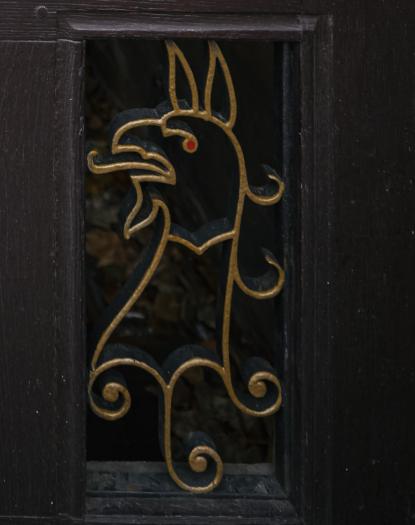 A detail from the back gate to Trinity College, with a gryphon in metal. 