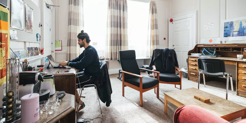 A male student studies in the common room of a second-year room set.