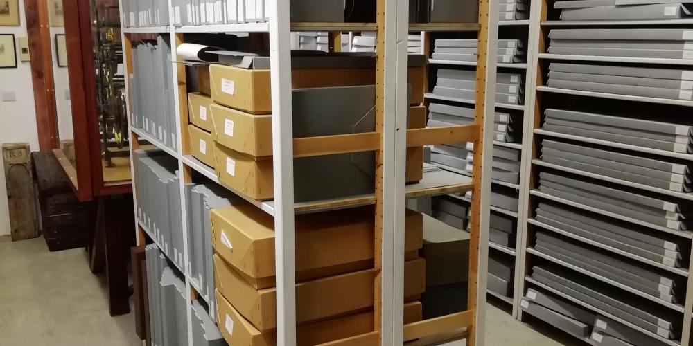 An image of the college archive storage area with shelving full of ledgers and boxes.