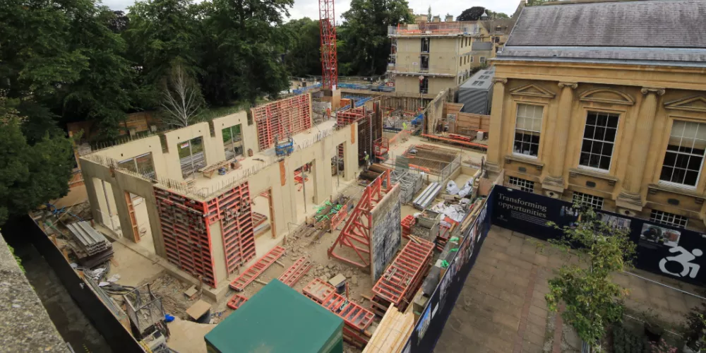An aerial view of the project site for the Levine building, including hoardings and the college library.