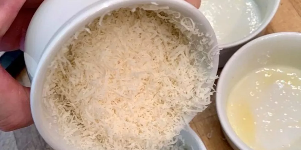 A ramekin lined with finely grated cheese.