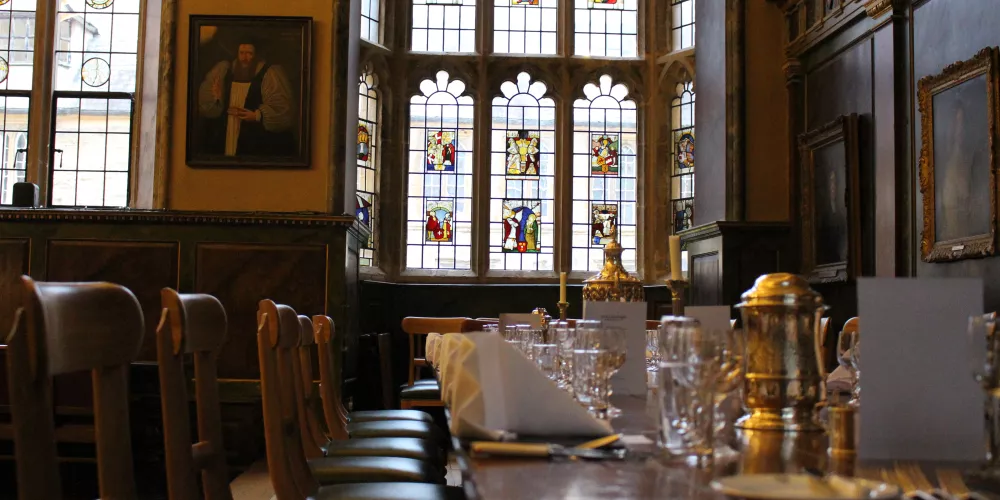 The Trinity Dining Hall with stained glass window in the background.