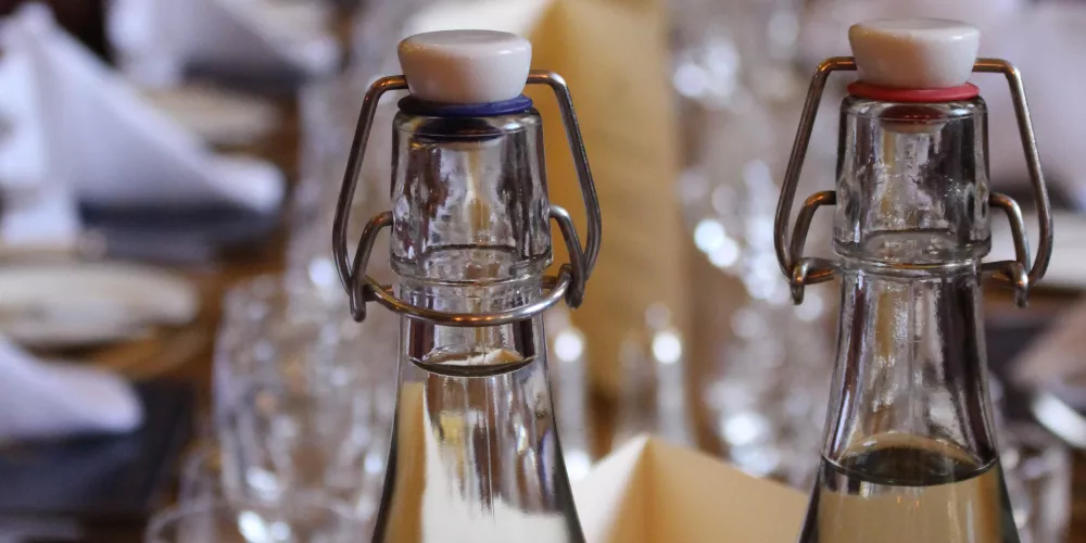A close up of serving water bottles at a long dining table.