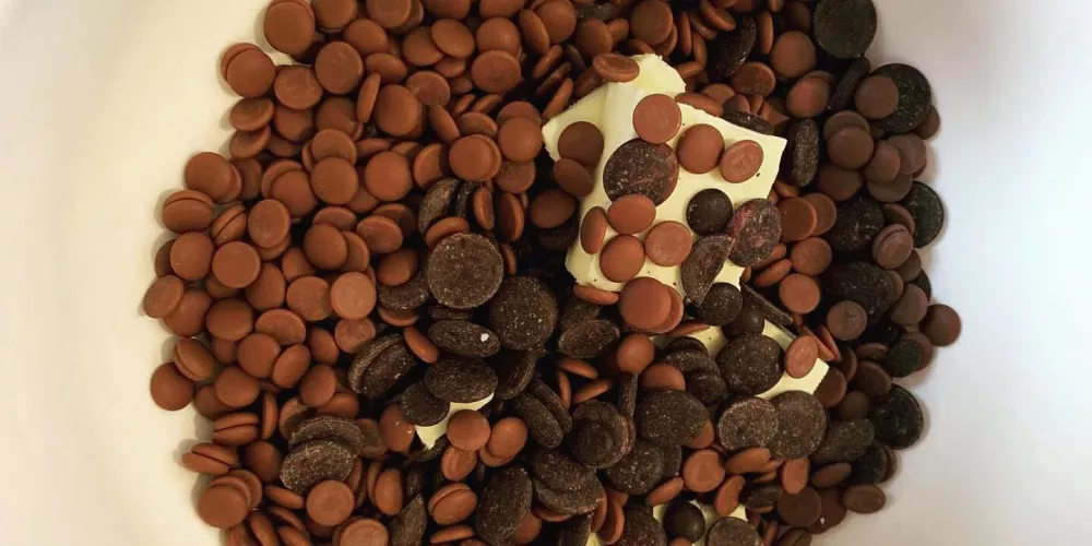 A bowl of butter and different chocolate chips.