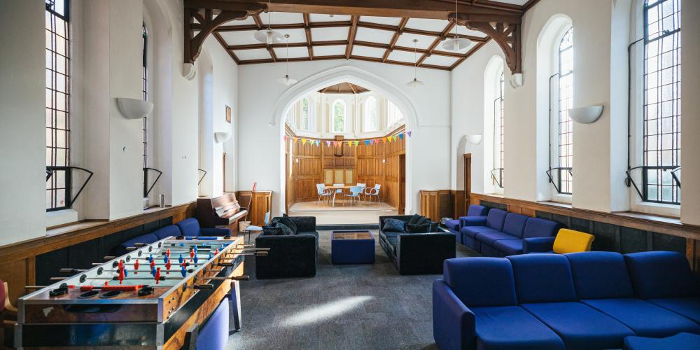 The common area of The Nunnery is shown with couches and table football.