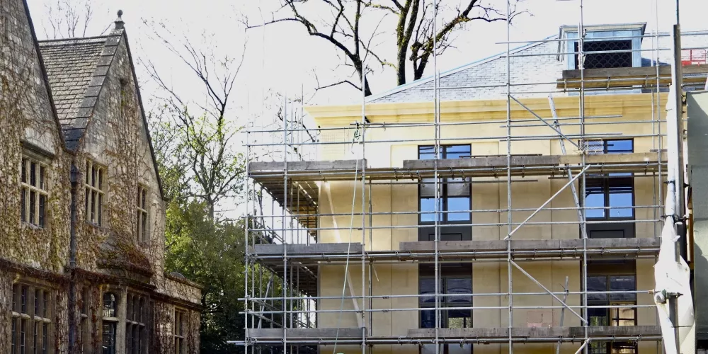 A view of the Levine Building from Library Quad; scaffolding remains and a digger can be seen in the foreground.