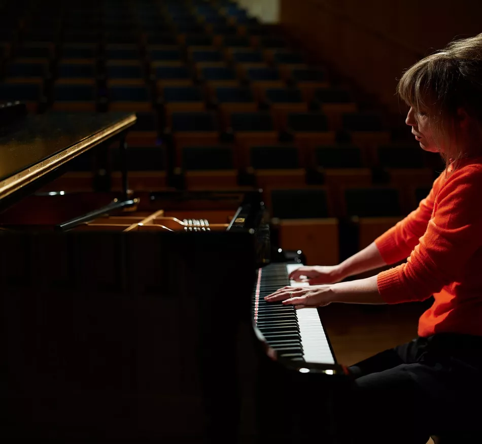 A female pianist practices the piano.