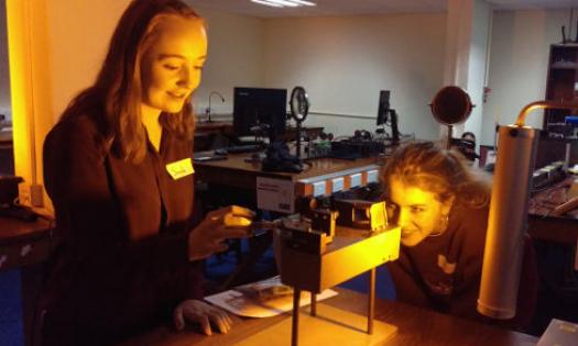 Two female students use a spectrometer.