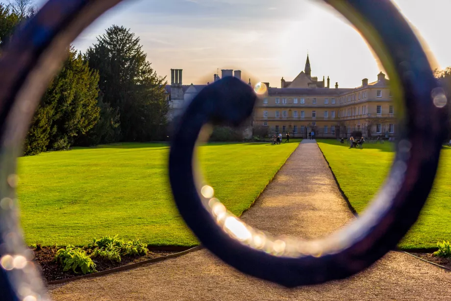 a view of Trinity's lawns through a whirl in the Parks Road gate.