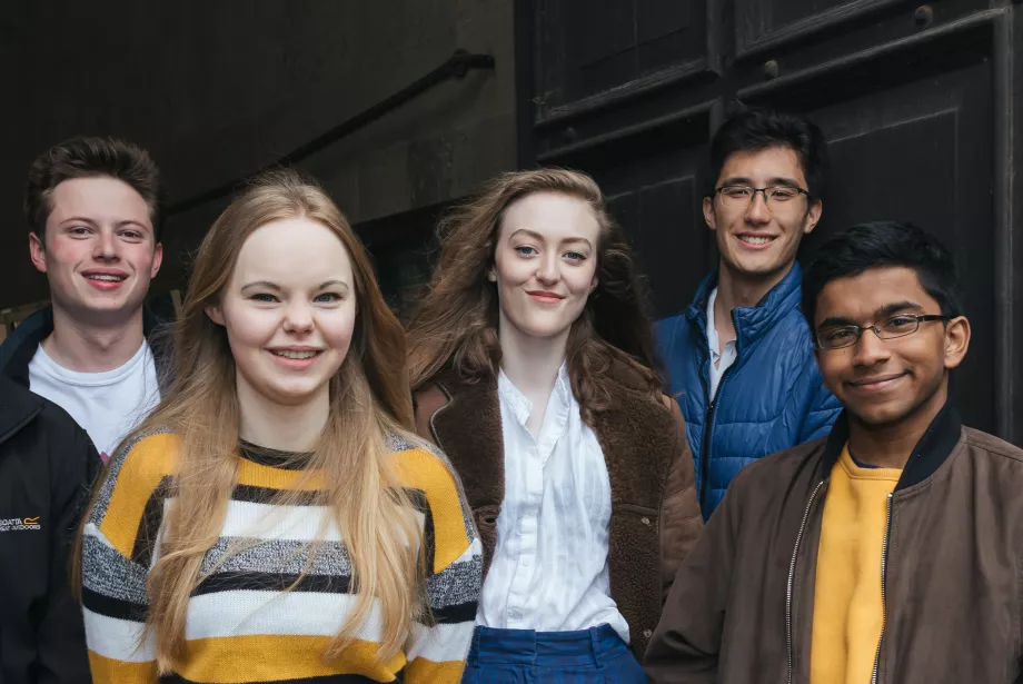 A photo of seven of Trinity's Student Ambassadors standing in front of the chapel arch.
