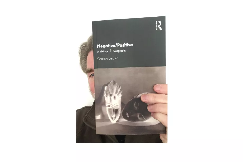 Geoff peeks out from behind a copy of his book