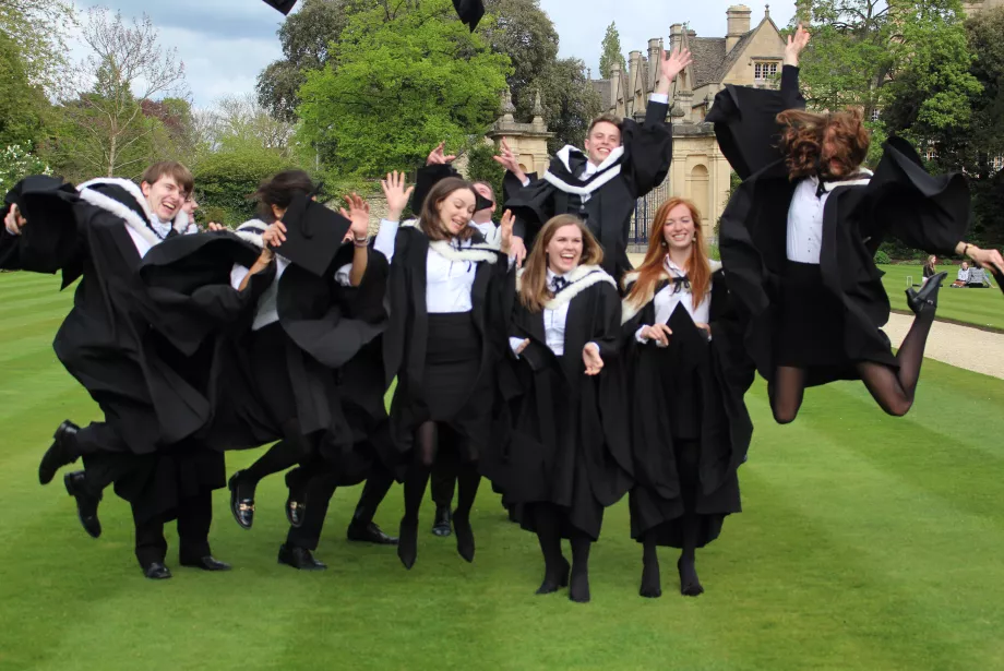 a group of students gathered on the lawns celebrating their graduation