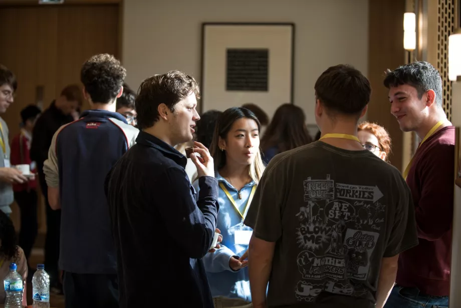 A group of students stand chatting in the Trinity College cafe. 