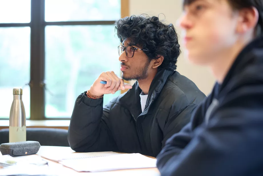 Profile image of two male students concentrating during a tutorial.