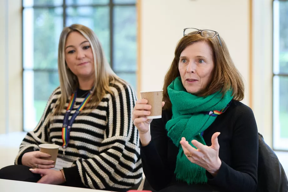 Two female teachers sit in a CPD seminar discussion.